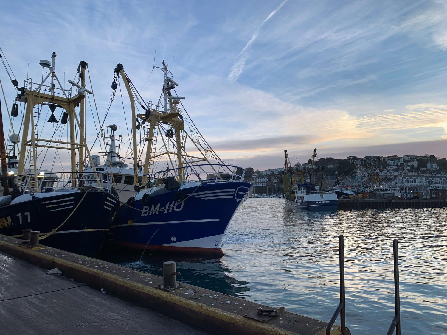 Serene Brixham Harbour - A picturesque view of a fishing boat anchored in Brixham harbour - The Seafood Connoisseur