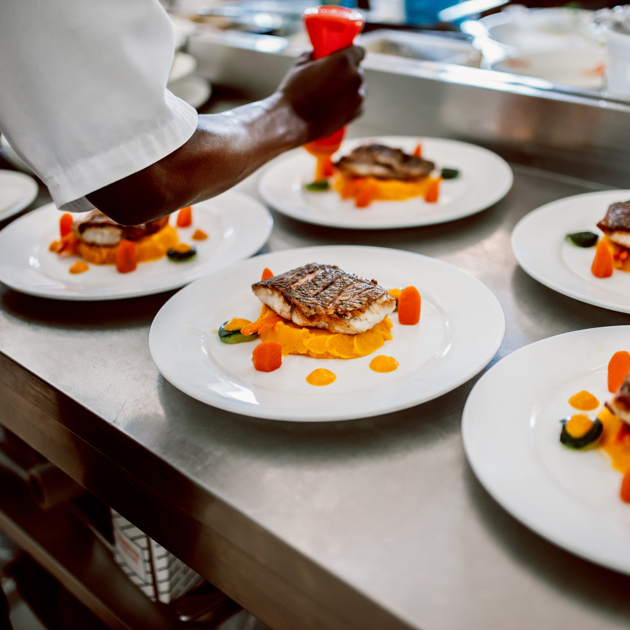 Cooked Seafood being plated by a chef